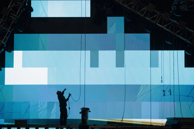 Silhouette of a technician installing a large LED video wall