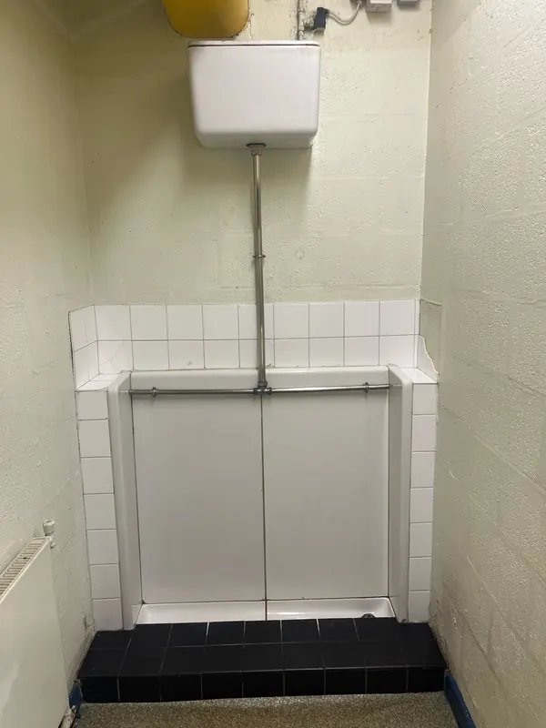 Washroom before: old slab urinal with high-level cistern